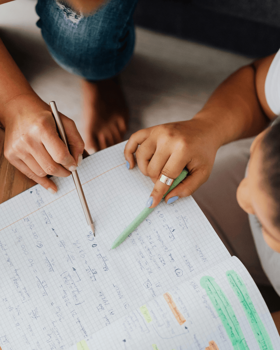 Hands helping a child with homework