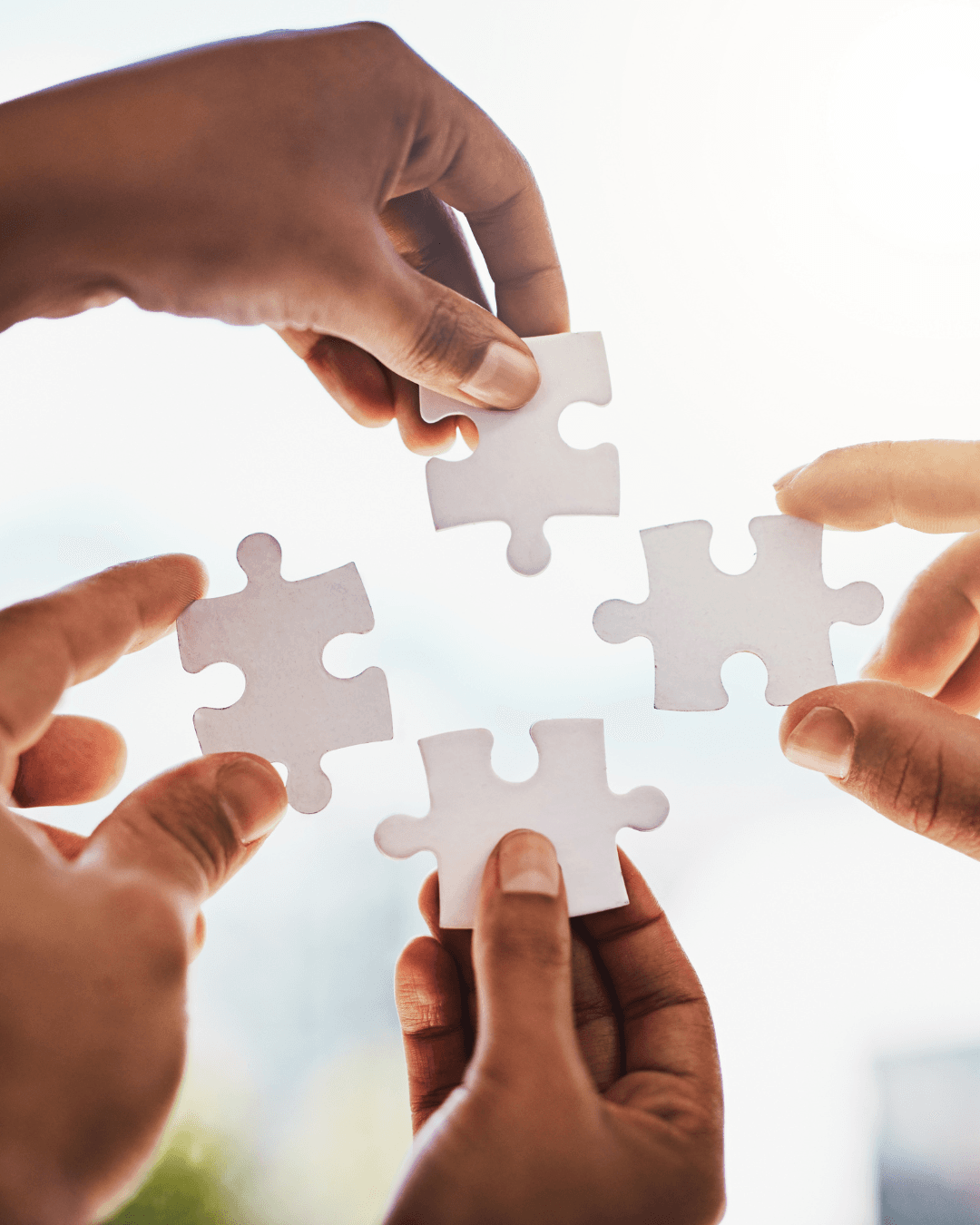 Hands joining puzzle pieces together